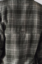 Close-up of the dark green and white check pattern on the women's shirt.