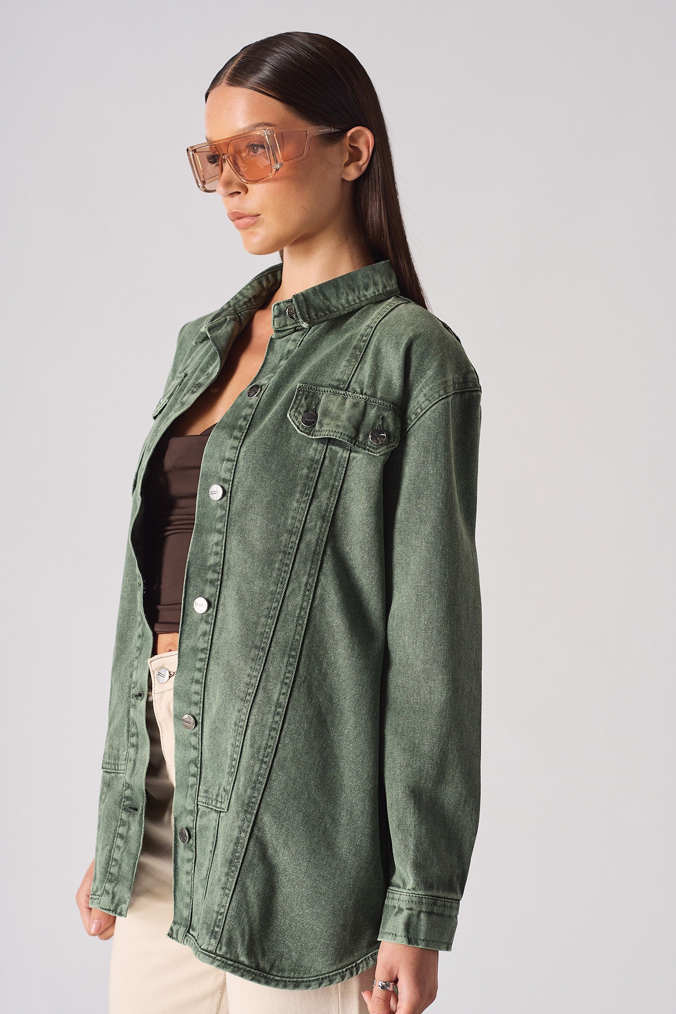 Side view of the dark green denim shirt, showing the stitch panel details.