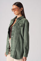 Side view of the dark green denim shirt, showing the stitch panel details.