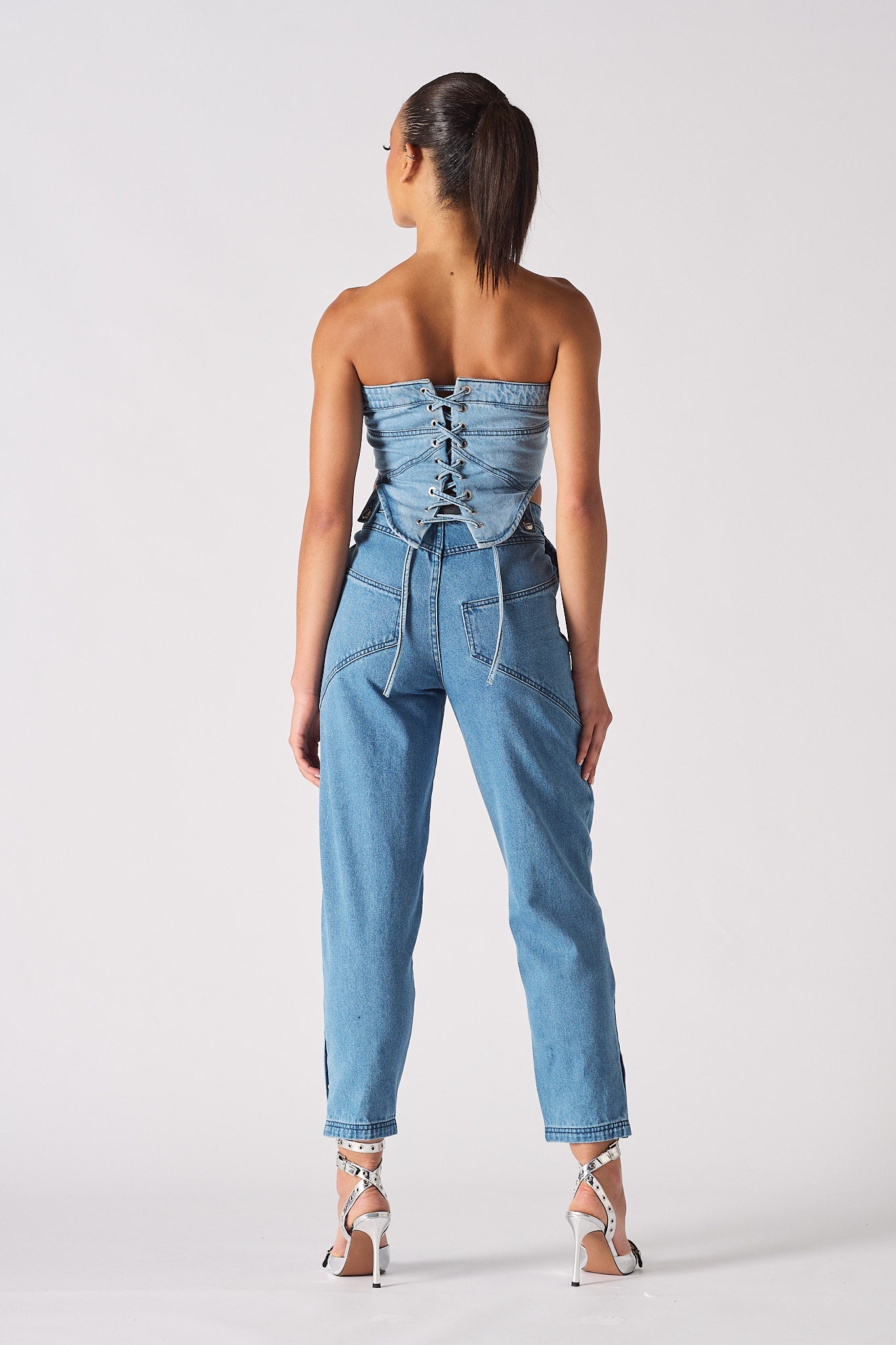 Back view of a model showing the lace-up detail on the denim corset.