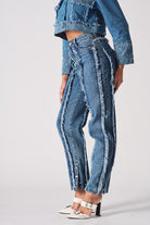 Side view of the women's distressed blue jeans showing the frayed seam detail.