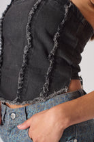 Detailed close-up of the distressed frayed seam texture on the corset.