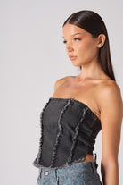 Another side profile view highlighting the frayed texture of the denim corset.