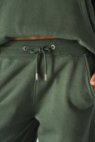 Detailed view of the drawstring with silver toggles on the green joggers for women.