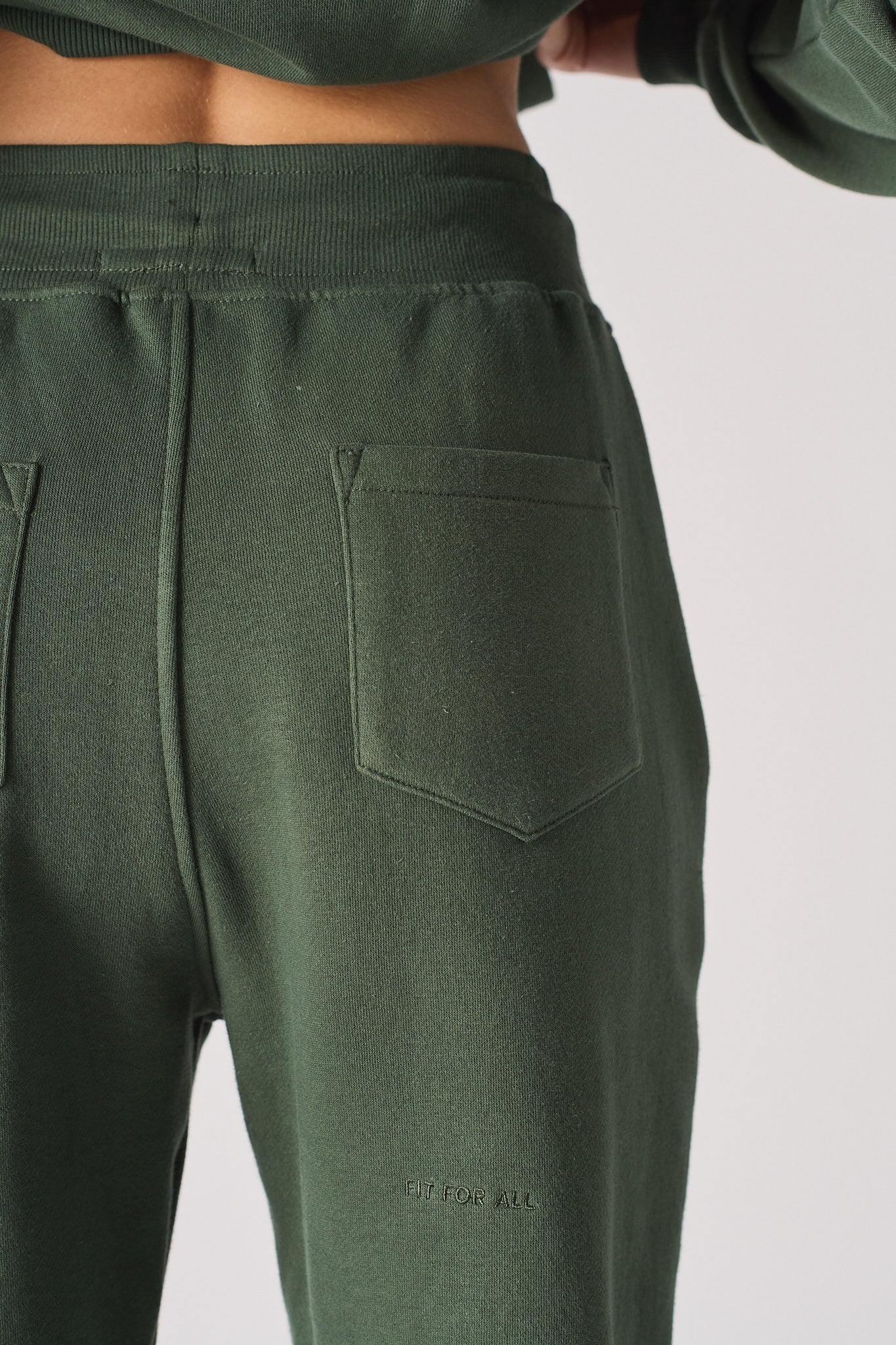 Close-up of the back pocket on the women's green tapered joggers.