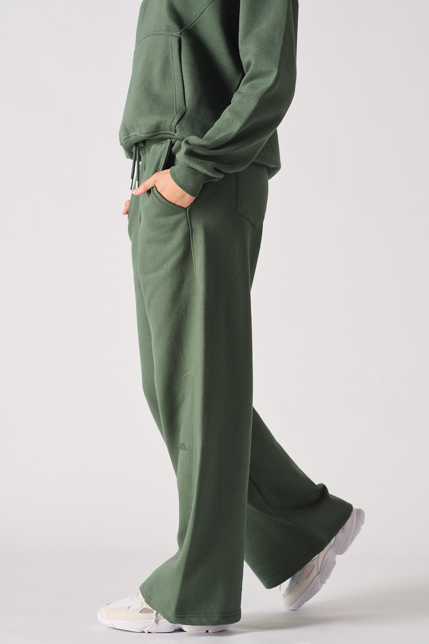 Side view of a model walking in the women's green wide-leg joggers.