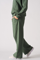 Side view of a model walking in the women's green wide-leg joggers.