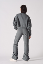 Rear view of model wearing grey crew neck jumper womens with matching flared trousers