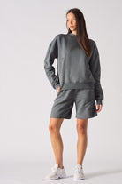 Close up view of the crew neckline and fabric texture on grey jumper