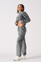 Side profile of a model showing the fit of the grey cuffed joggers for women.