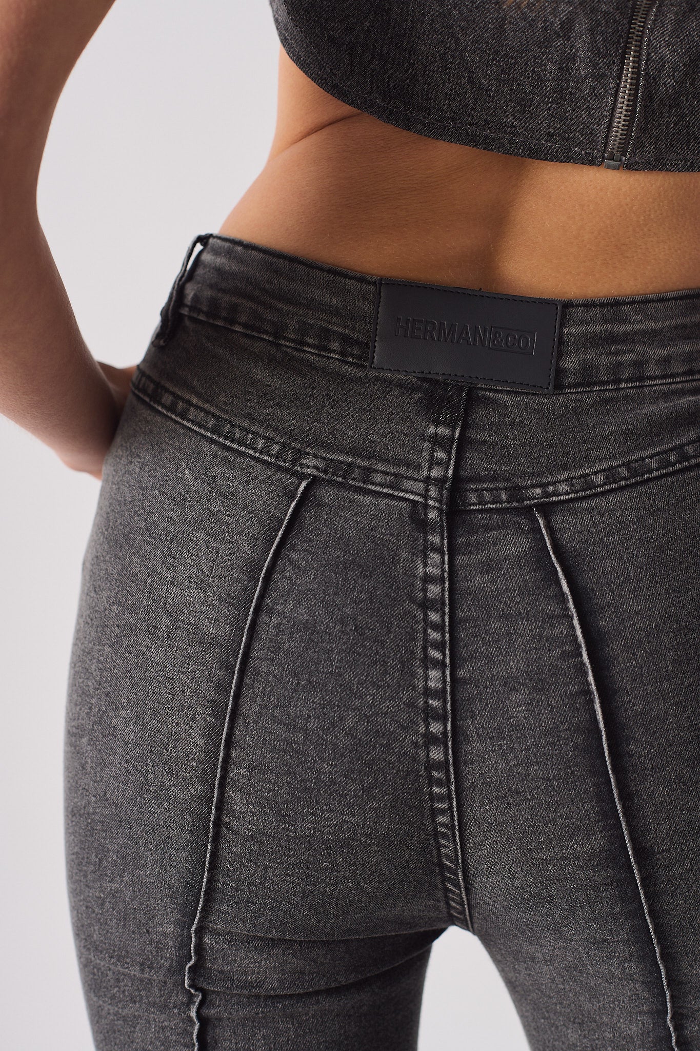 Close-up of the back and seam detail on the grey flare jeans.