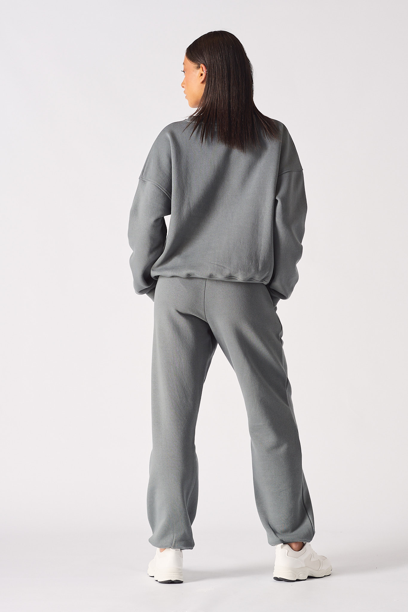 Rear full body view of model in a relaxed fit womens oversized grey sweatshirt outfit