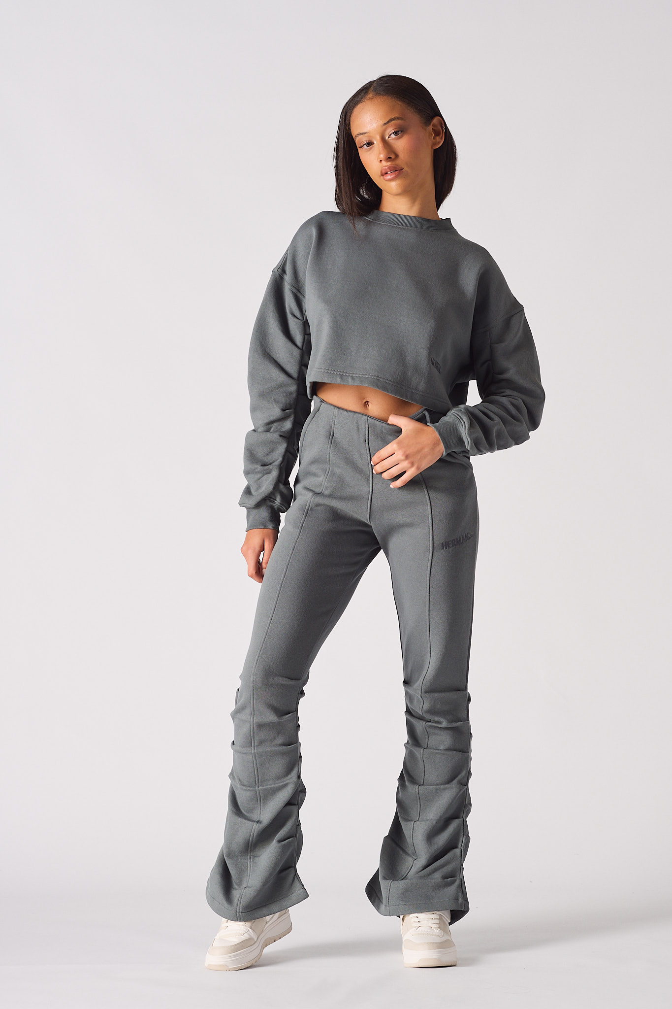 Full length front view of model wearing grey ruched flare joggers