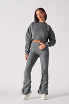 Full length front view of model wearing grey ruched flare joggers