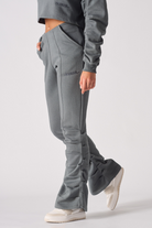 Close up detail of the HERMAN logo embroidery on grey ruched joggers