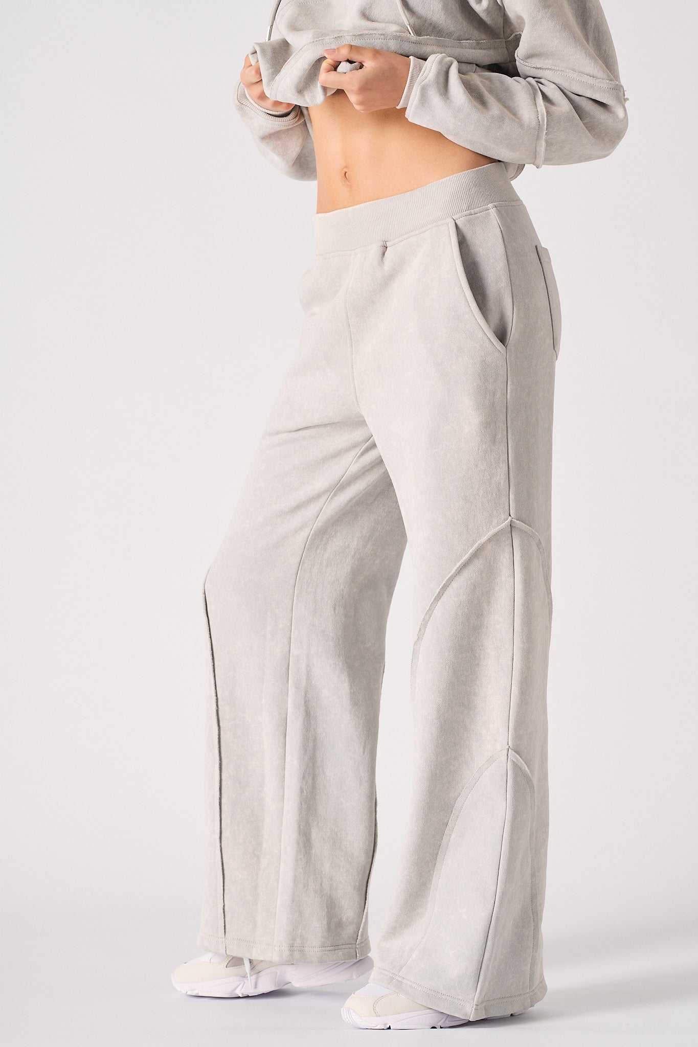 Angled side view of the grey seam detail joggers.
