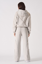 Back view of a model in the grey wide-leg joggers and matching cropped hoodie.