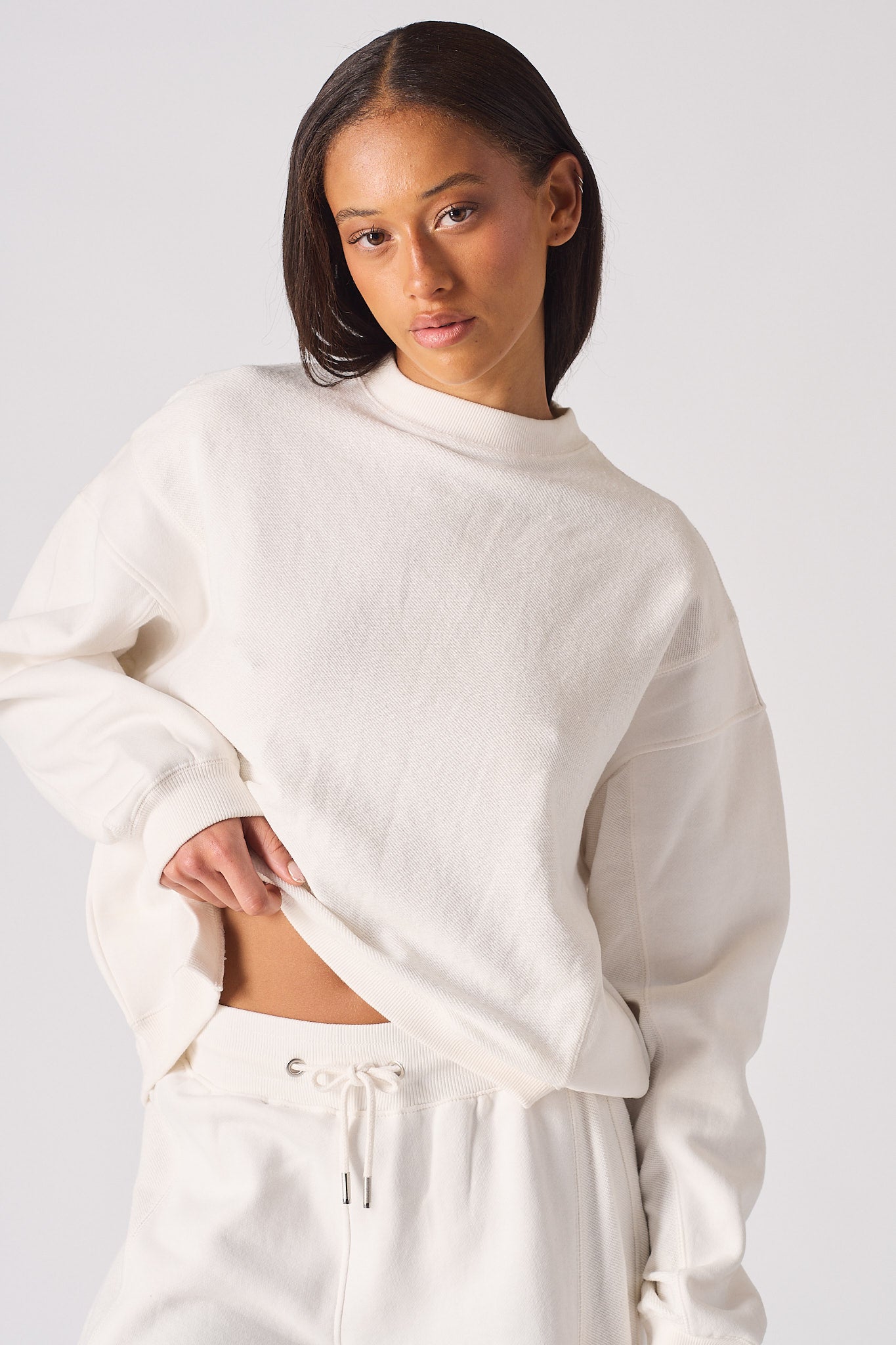 Close up of the high neck and logo embroidery on white crew neck jumper womens