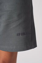 Close up of HERMAN logo embroidery near the hem of womens shorts