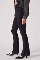 Side profile of a model showing the fit of the high-rise flare jeans in black.