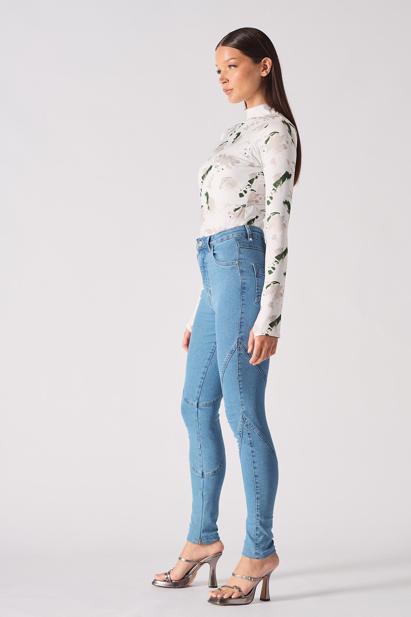 Side profile of a model showing the fit of the high-waisted blue skinny jeans.