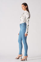 Side profile of a model showing the fit of the high-waisted blue skinny jeans.