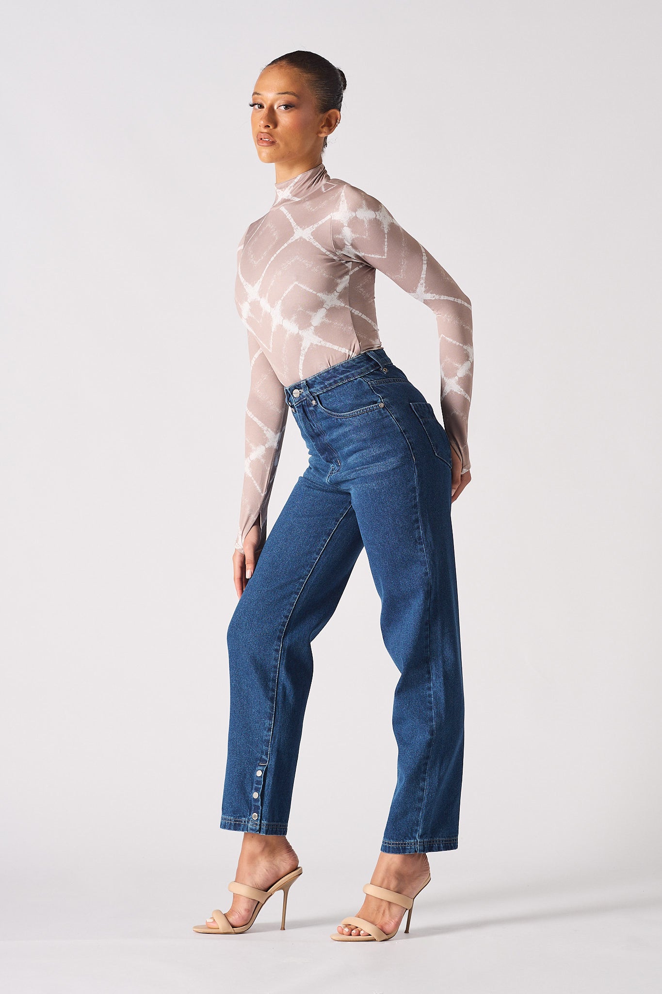 Side view of a model showing the fit of the jeans with whiskers.