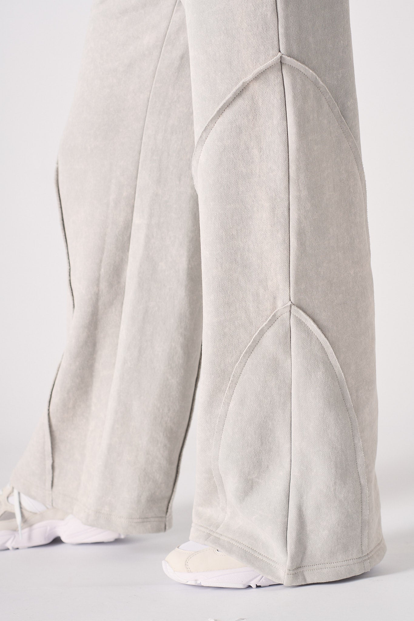 Close-up of the hem and seam detail on the grey joggers.