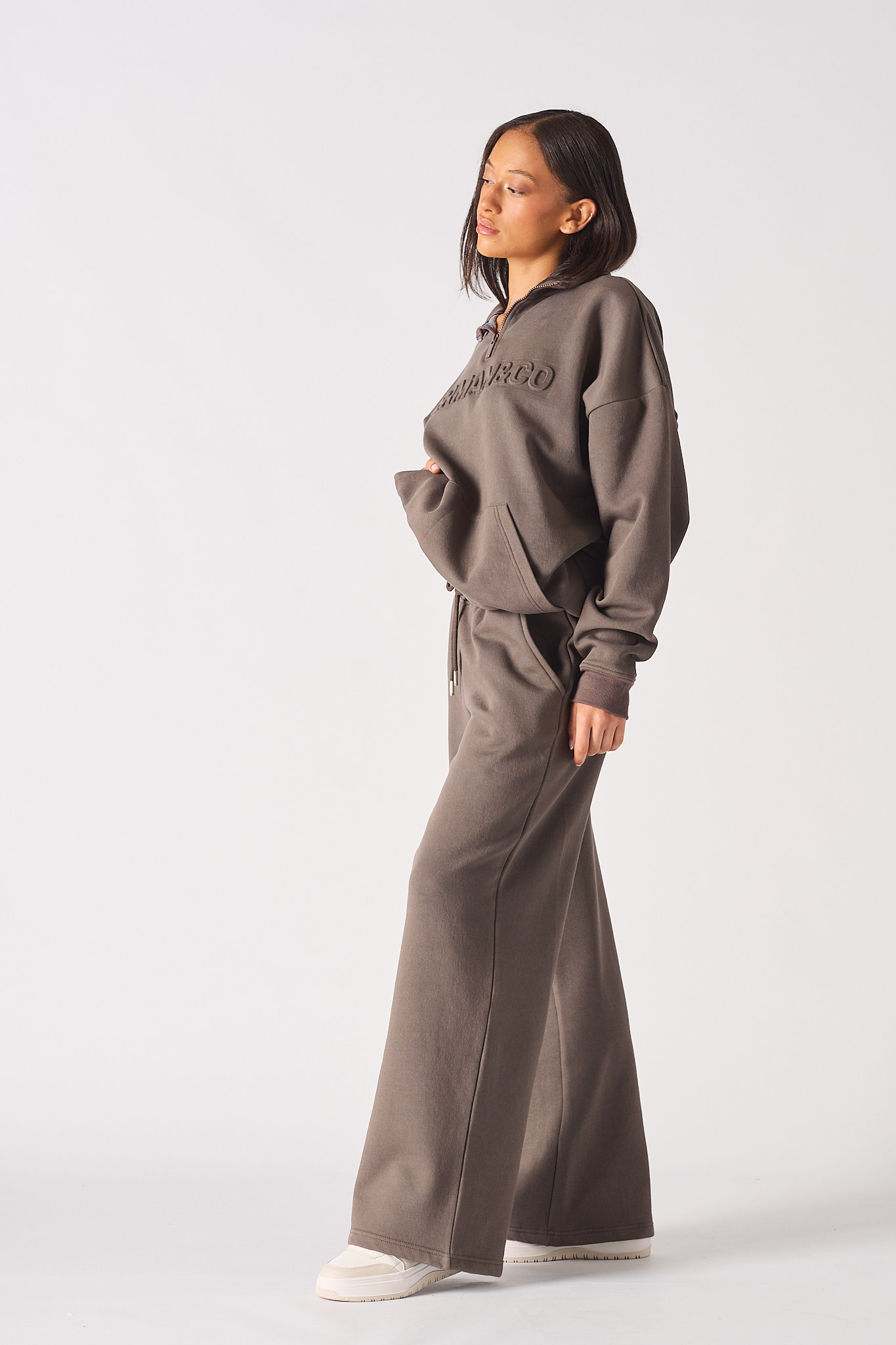 Side profile of a model wearing the ladies' brown baggy joggers.