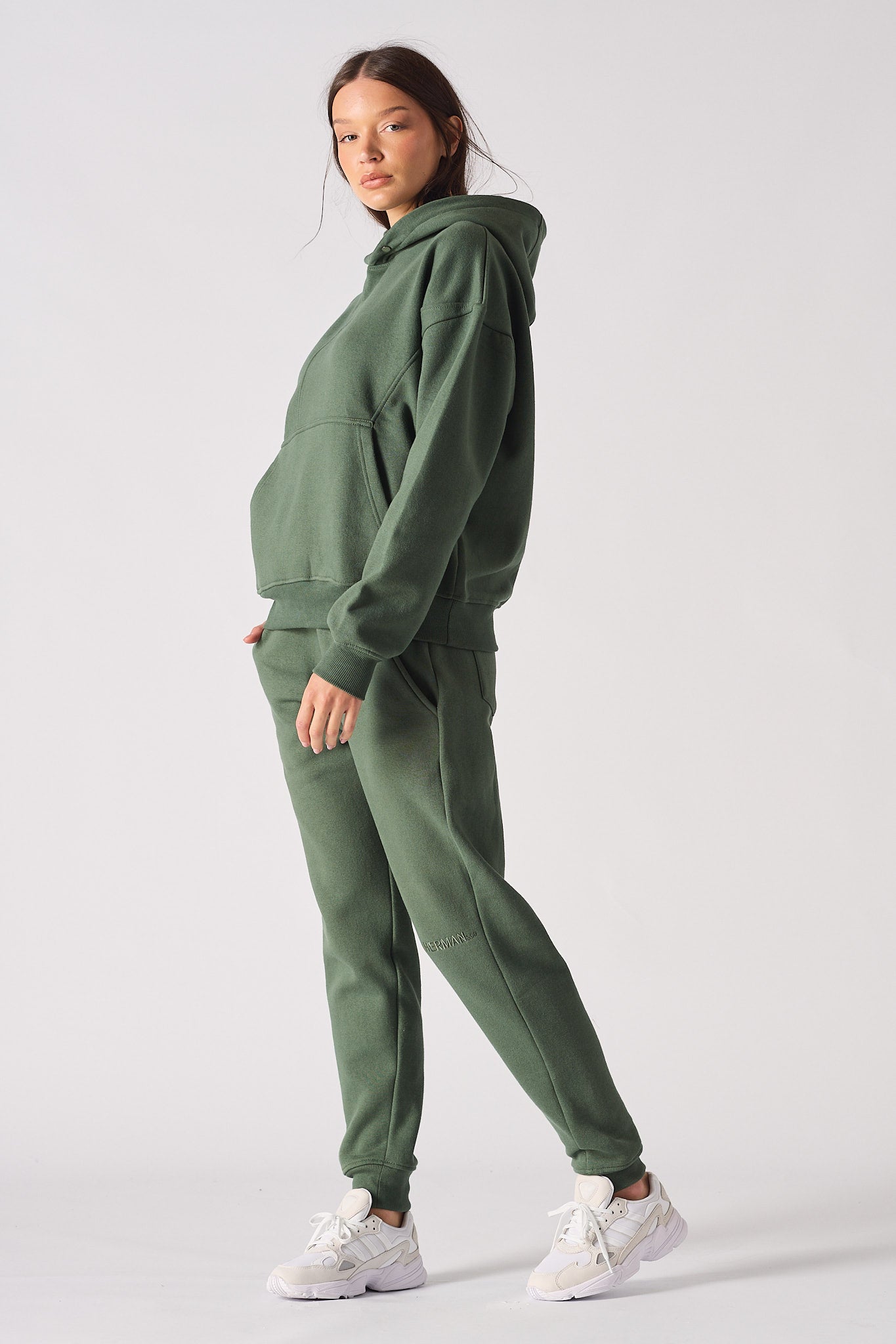 Side profile of model wearing a comfortable dark green hoodie