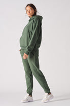Side profile of model wearing a comfortable dark green hoodie