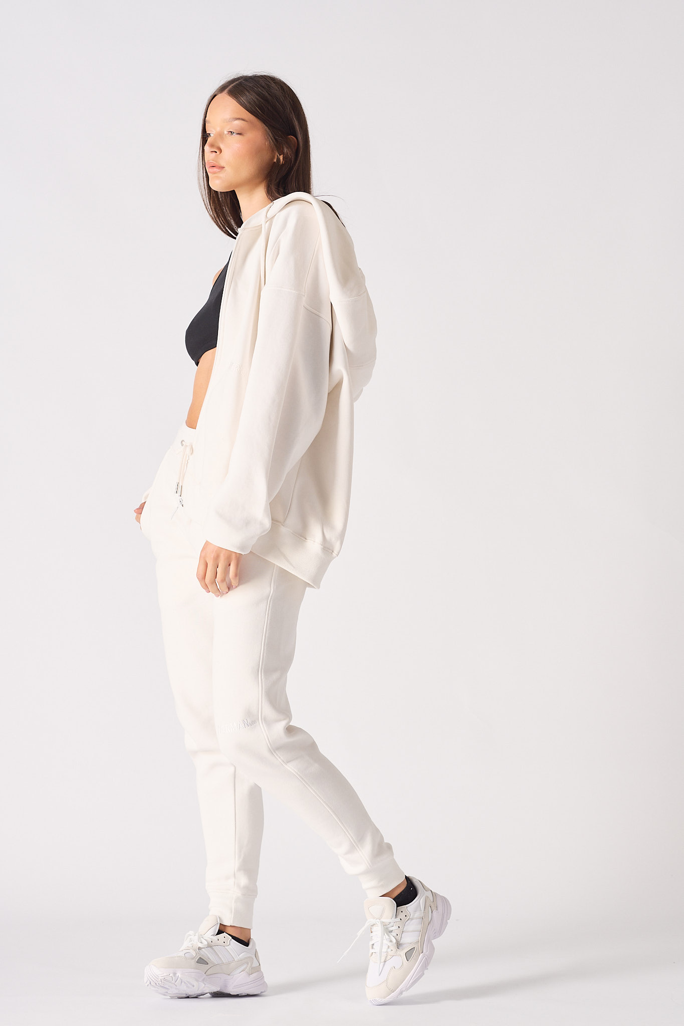 A model walking in the ladies' white zip-up hoodie.