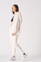 A model walking in the ladies' white zip-up hoodie.