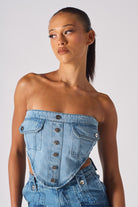 Close-up of a model wearing the light blue strapless denim corset with pockets.