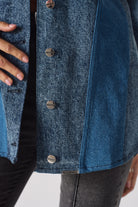 A model showing the fit of the longline acid wash denim shirt for women.