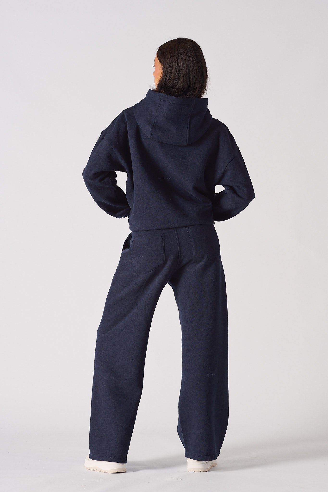 Back view of a model in the navy jogger for women and matching hoodie set.