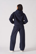 Back view of a model in the navy jogger for women and matching hoodie set.