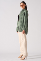 Side profile of a model wearing the oversized green denim shirt.