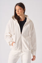 A model in the oversized white zip-up hoodie for women.