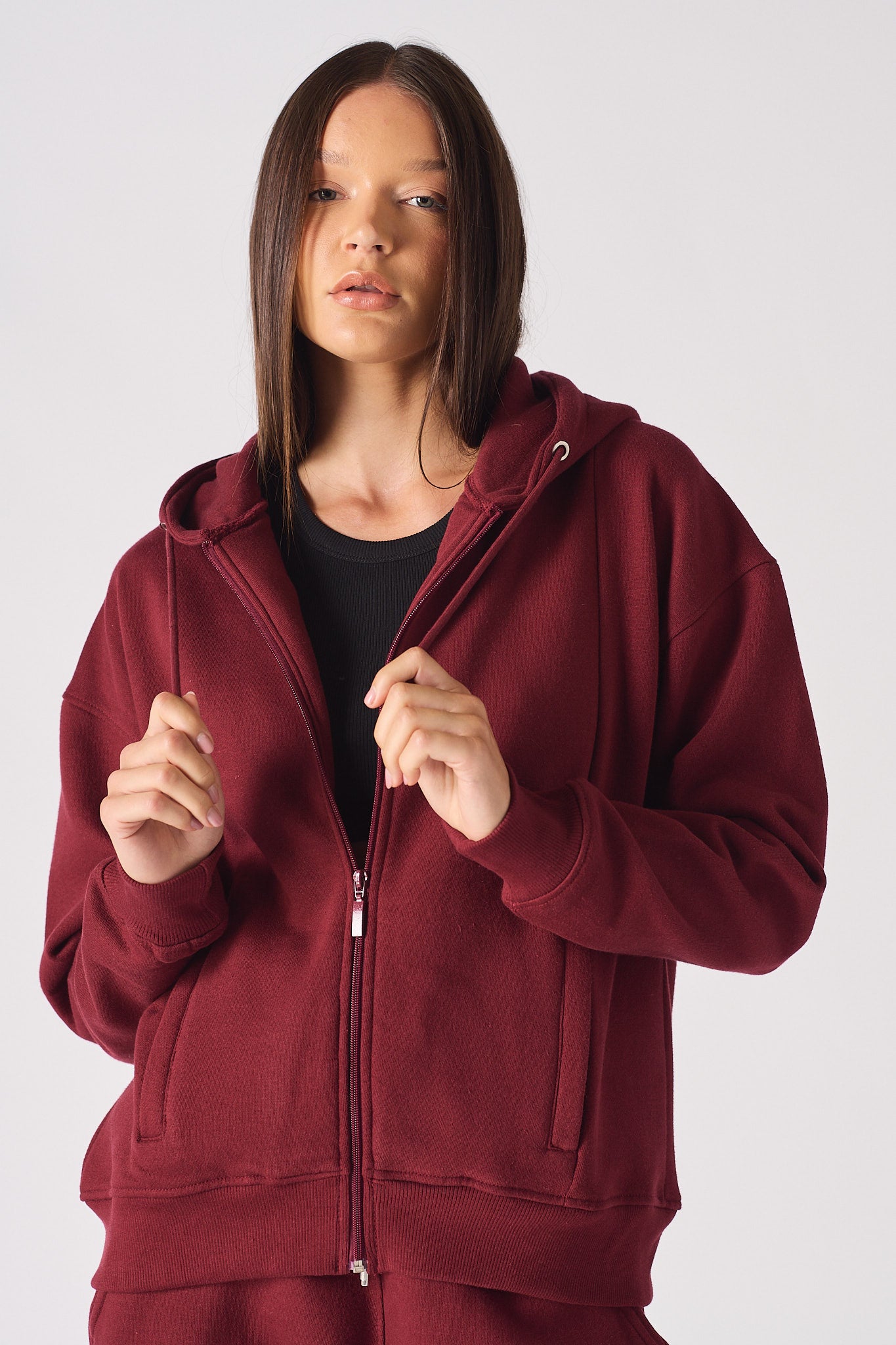 A model wearing the red hoodie for women zipped open.