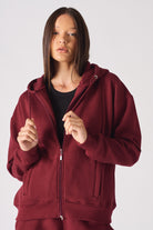 A model wearing the red hoodie for women zipped open.