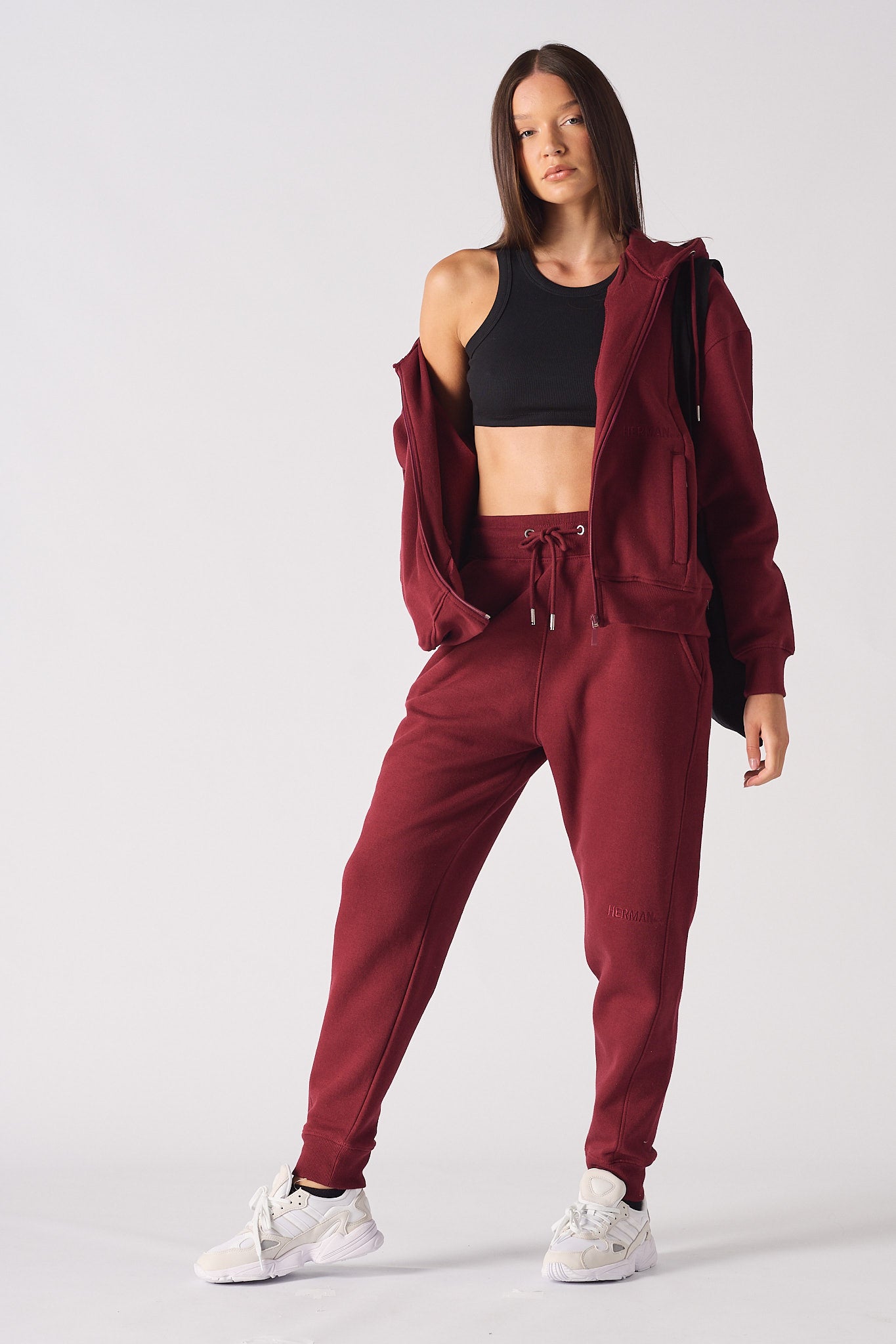 A model showing the oversized fit of the red zip-up hoodie for women.