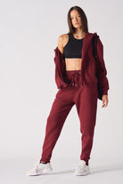 A model showing the oversized fit of the red zip-up hoodie for women.