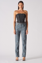 A model styled in the black textured corset with printed trousers.