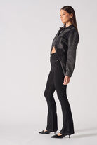 A model styled in the black high-rise flare jeans with a matching shirt.