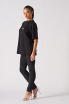 A model showing how to style the black skinny biker jeans for women.