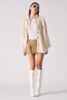 A model showing how to style the beige checked overshirt.