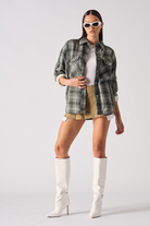 A model showing how to style the dark green checked overshirt.