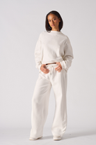 A model styled in the white wide-leg joggers for women with a matching sweatshirt.
