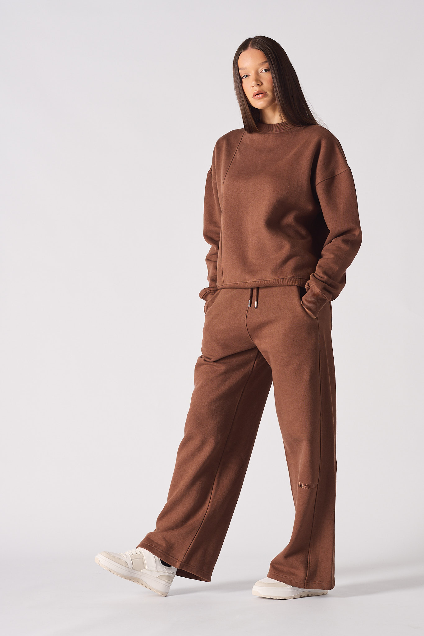 A model styled in the wide-leg brown joggers for women and a matching jumper.